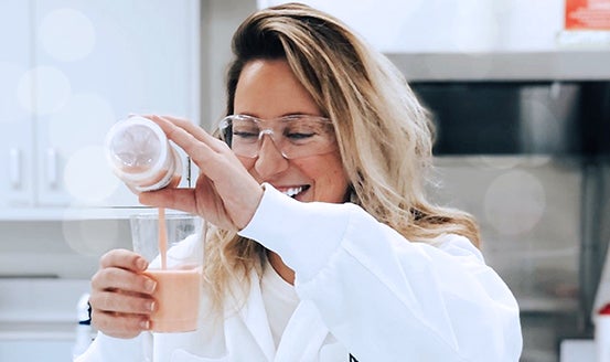 A woman employee testing liquid mixtures in a bottle
