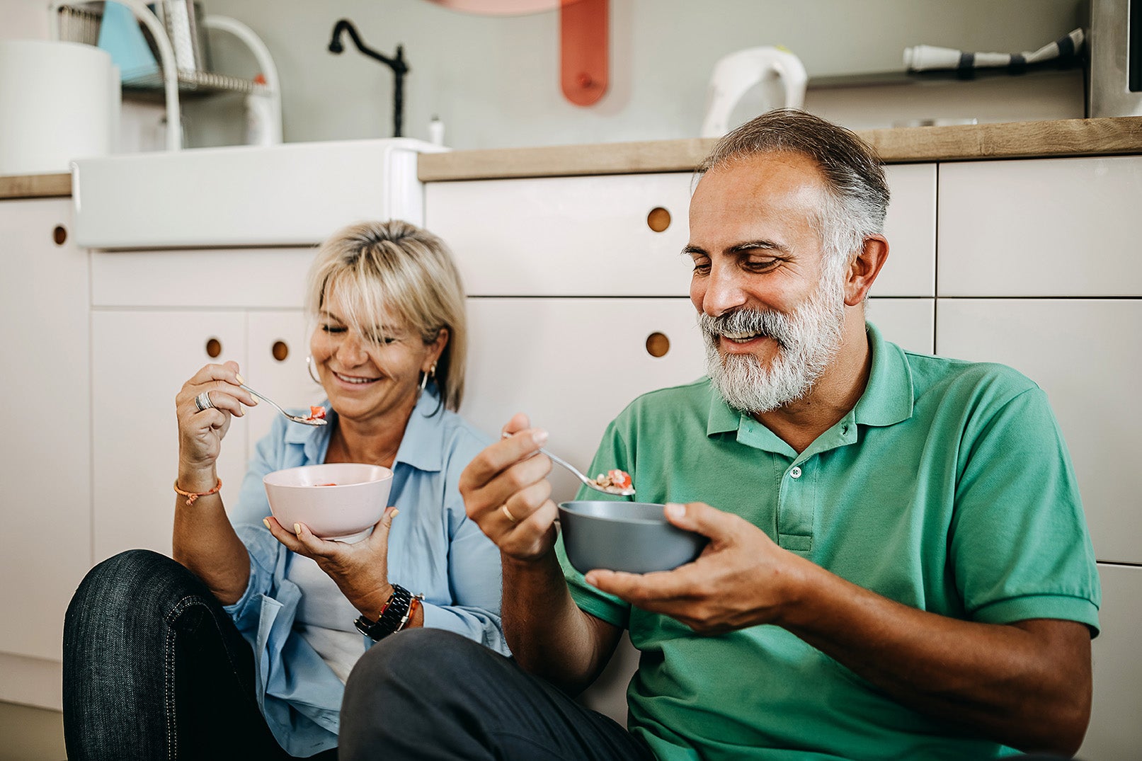 Senior man and woman eat breakfast on the kitchen floor