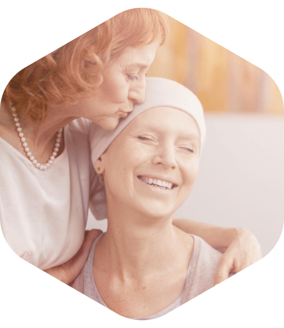 Person wearing a headscarf being comforted by another person indoors.