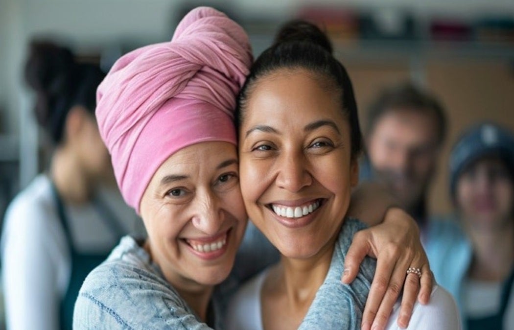 Two people hugging and smiling in an indoor setting.