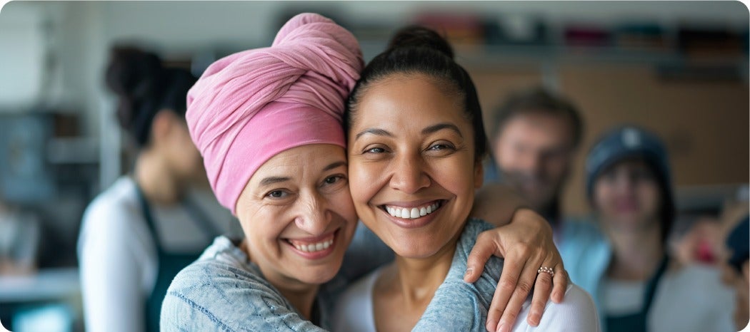 Two people hugging and smiling in an indoor setting.